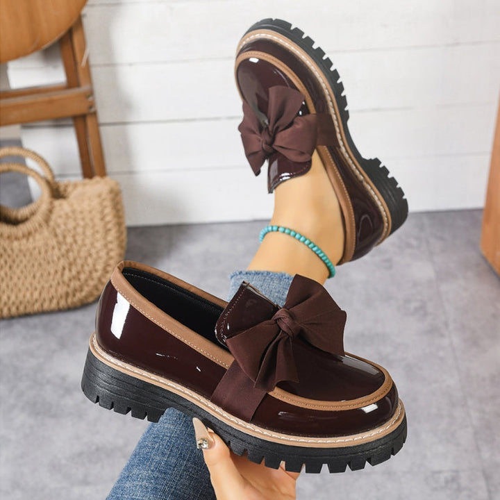 Burgundy slip-on loafers with large bow and chunky tread sole