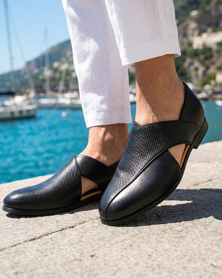 Black slip-on loafers with woven strap, smooth leather toe, and low outsole