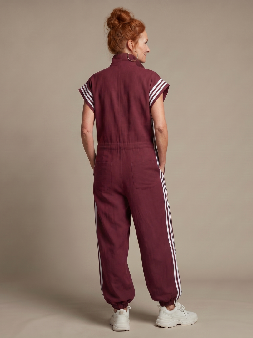 Women’s sleeveless zip-front jumpsuit in maroon, back view with white side stripes