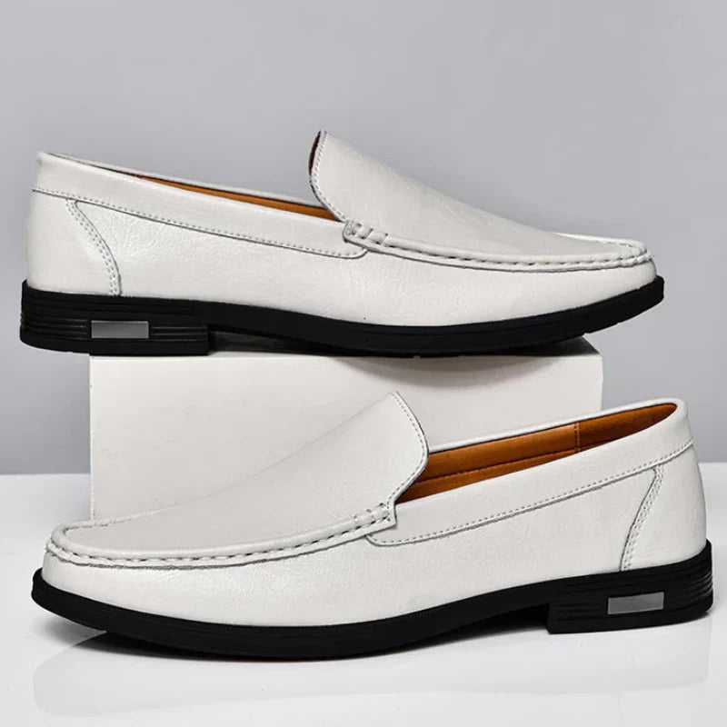 White leather loafer with metal bar strap and contrast stitching, flat rubber sole