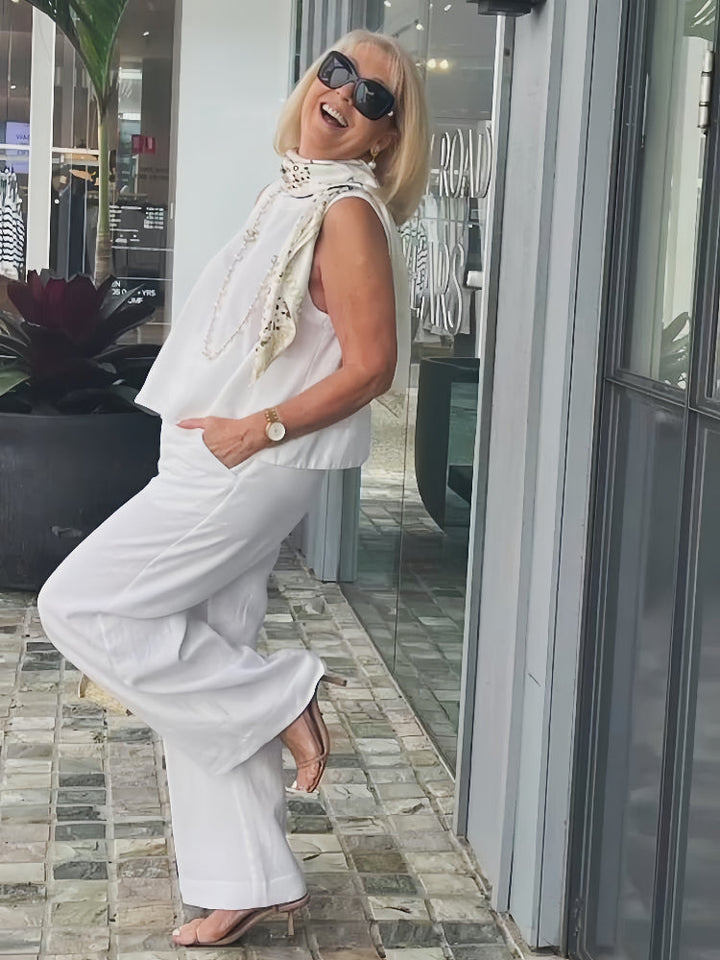White sleeveless layered outfit with beaded stand collar and wide-leg pants