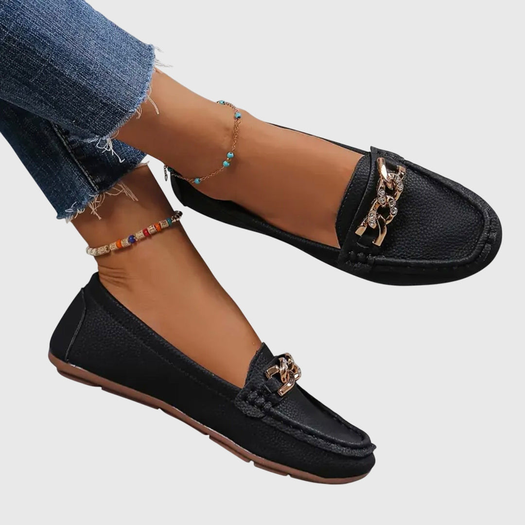 Black chain loafers with gold-tone chain strap ornament and moc-toe stitching