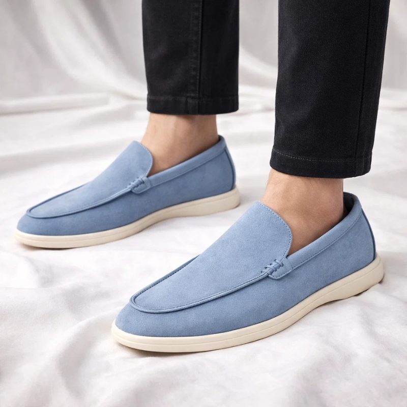 Blue suede slip-on loafer with stitched vamp seam and white rubber sole