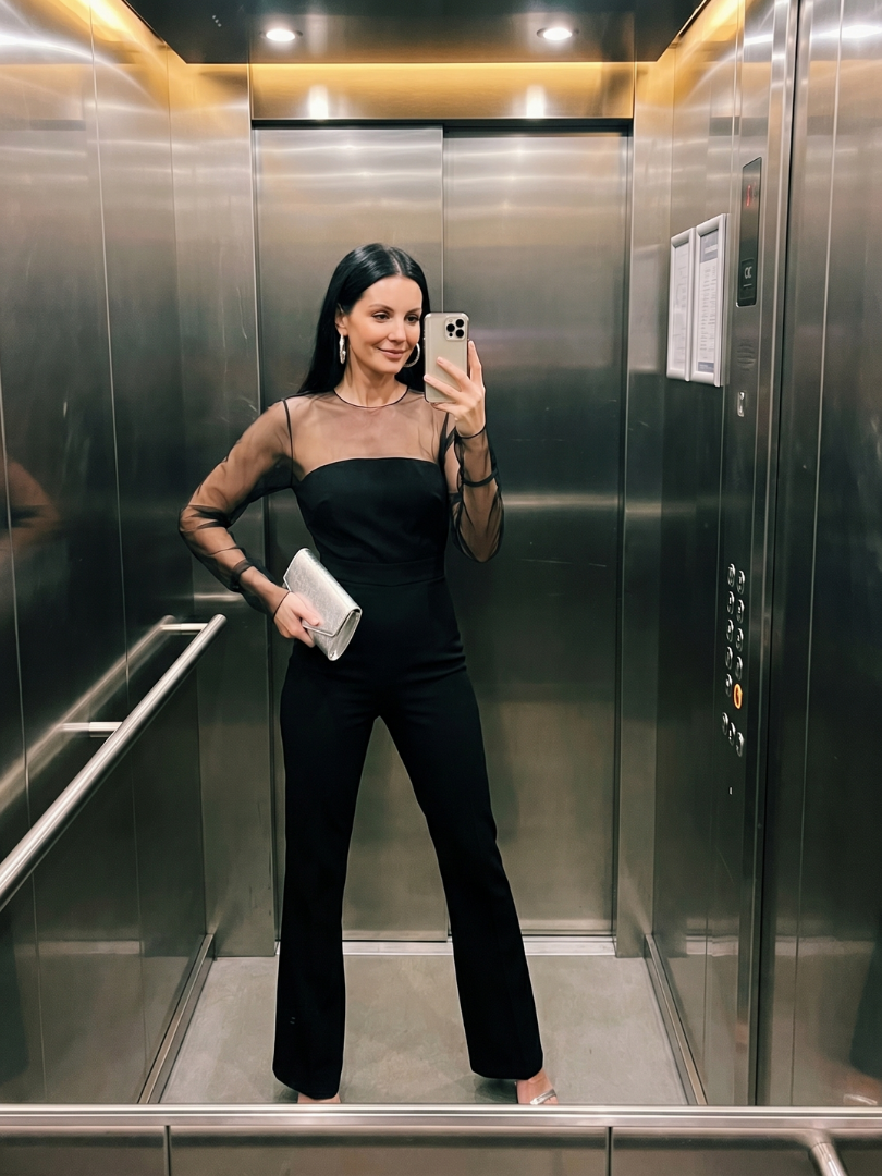 Black sheer-sleeve jumpsuit with straight neckline and wide-leg pants, full body