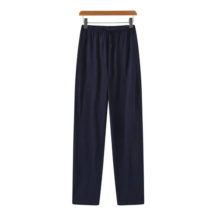 Navy linen pants with elastic waistband, drawstring, and relaxed straight legs.