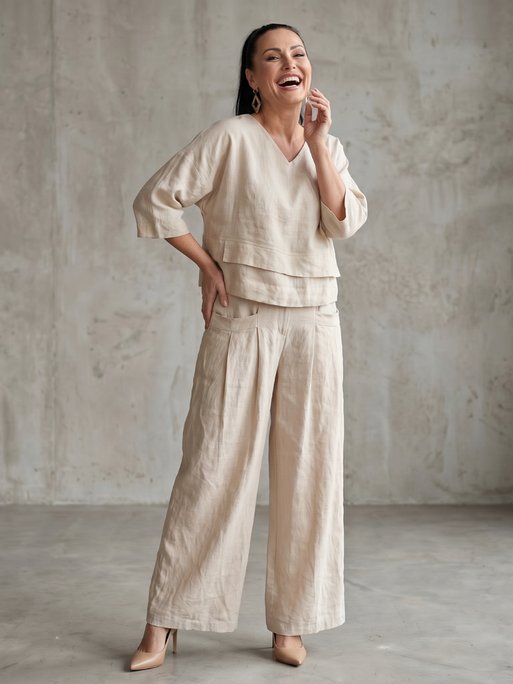 Beige two-piece wide-leg pants set with V-neck tunic top and relaxed wide-leg trousers.
