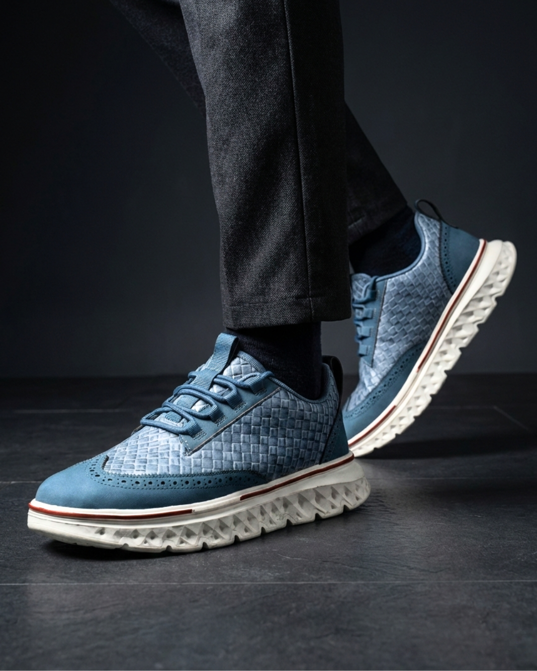 Blue lace-up dress sneaker with textured upper and red-accent rubber outsole edge