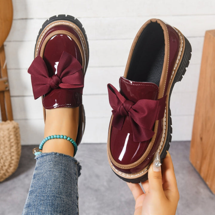 Burgundy slip-on loafers with oversized bow and chunky tread sole