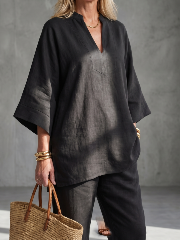 Black women’s V-neck tunic top with side slits and matching pants, close-up front