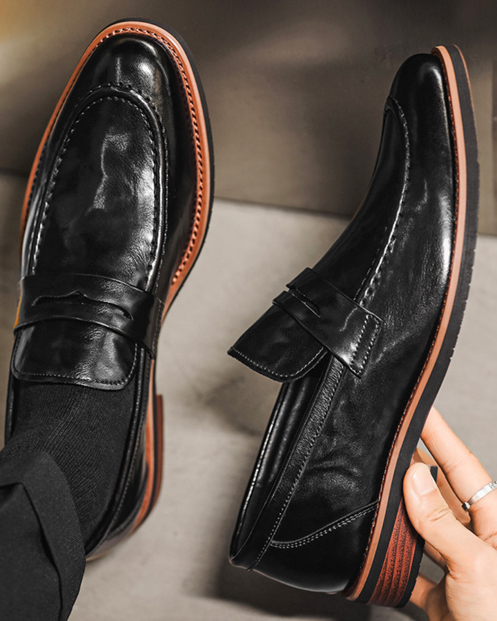 Black leather loafer with strap detail, contrast stitching, and low sole