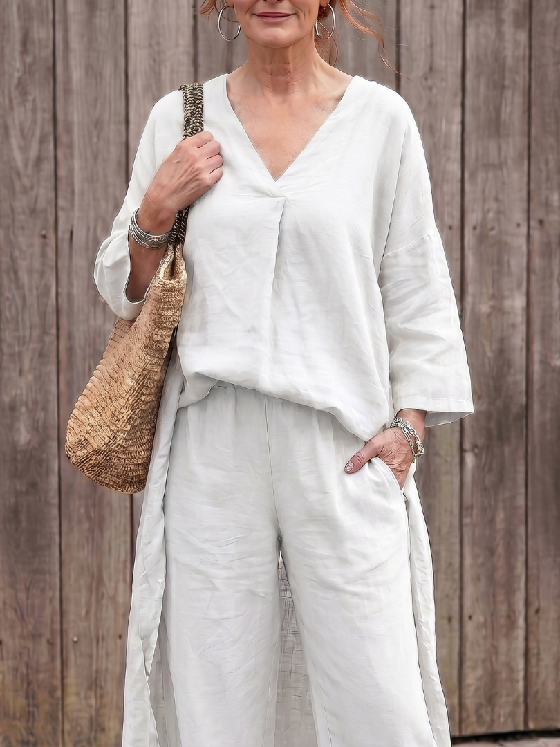 White linen two-piece set close-up: V-neck tunic top with loose sleeves and matching pants.