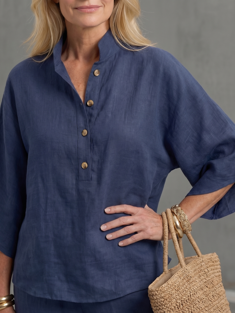 Navy button-up blouse with gold buttons and loose wide sleeves, paired with matching pants.