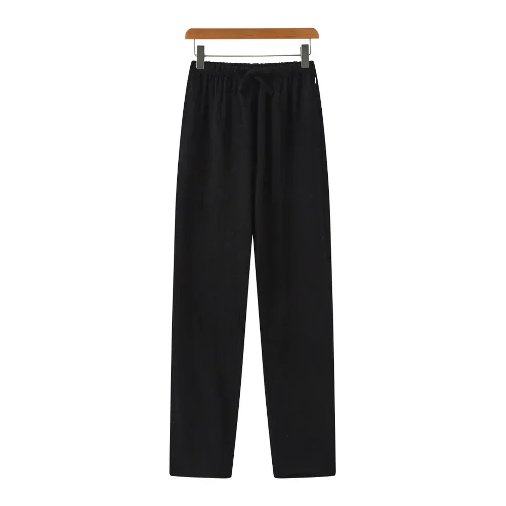 Black linen pants with elastic waistband and drawstring, relaxed straight legs.