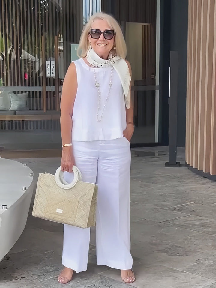 White sleeveless layered top with long beaded detail and matching wide-leg pants