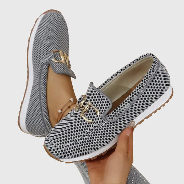 Gray women's slip-on loafers with gold buckle ornament, cushioned textured upper