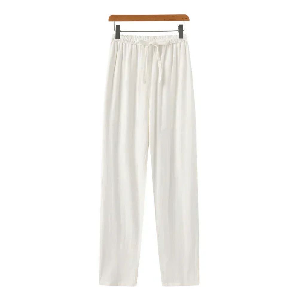 White linen pants with elastic waistband, drawstring, and relaxed straight legs.