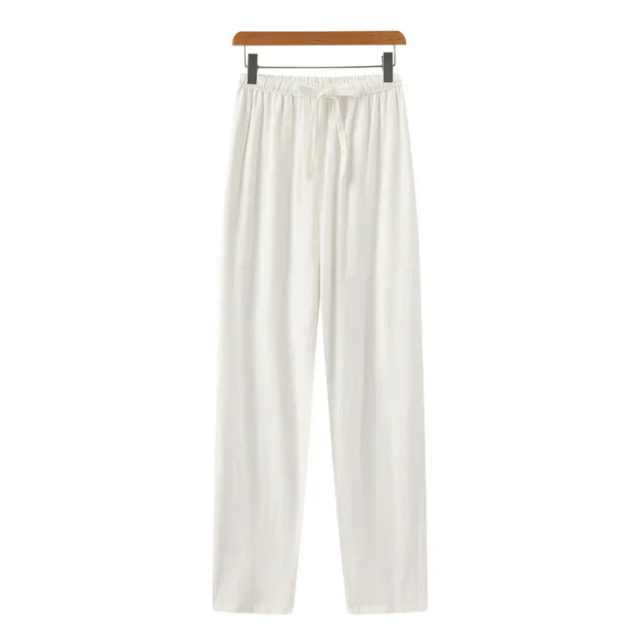 White linen pants with elastic waistband, drawstring, and relaxed straight legs.