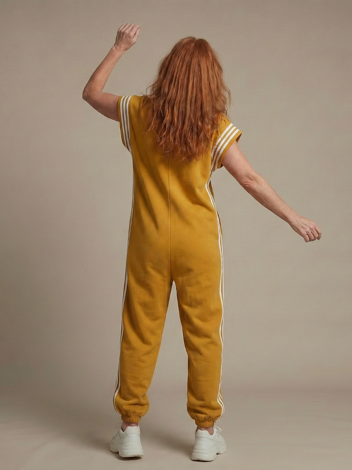 Women’s sleeveless zip-front jumpsuit in yellow, back view with white stripe side panels