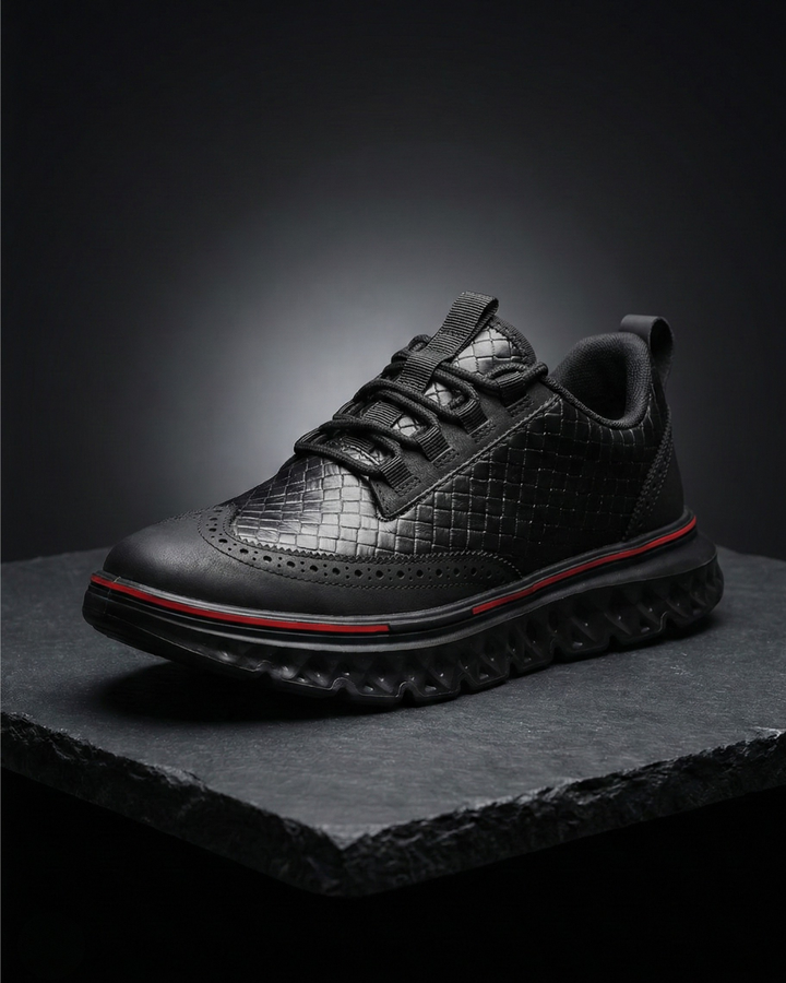 Black dress sneaker with quilted texture, lace-up front, and red-trim tread
