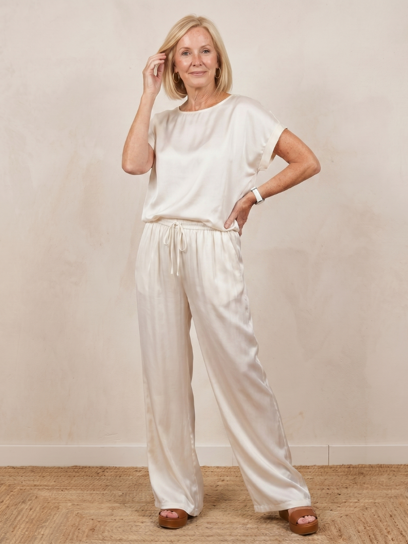 Women’s white two-piece set with short-sleeve top and wide-leg drawstring pants.