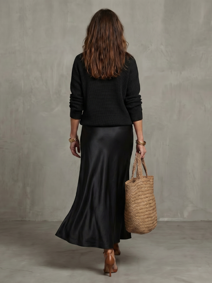 Women’s satin two-piece set in black: rear view of knit sweater and long satin skirt
