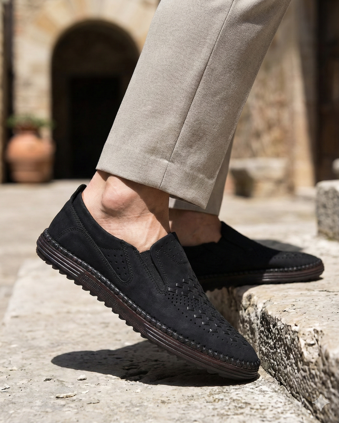 Black perforated leather slip-on loafer with stitched edge and padded vamp