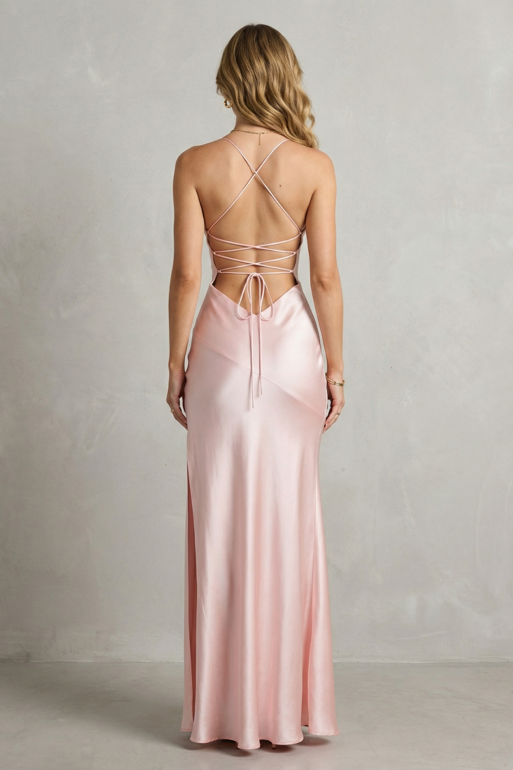 Pink satin maxi dress back view with crisscross straps and high slit.