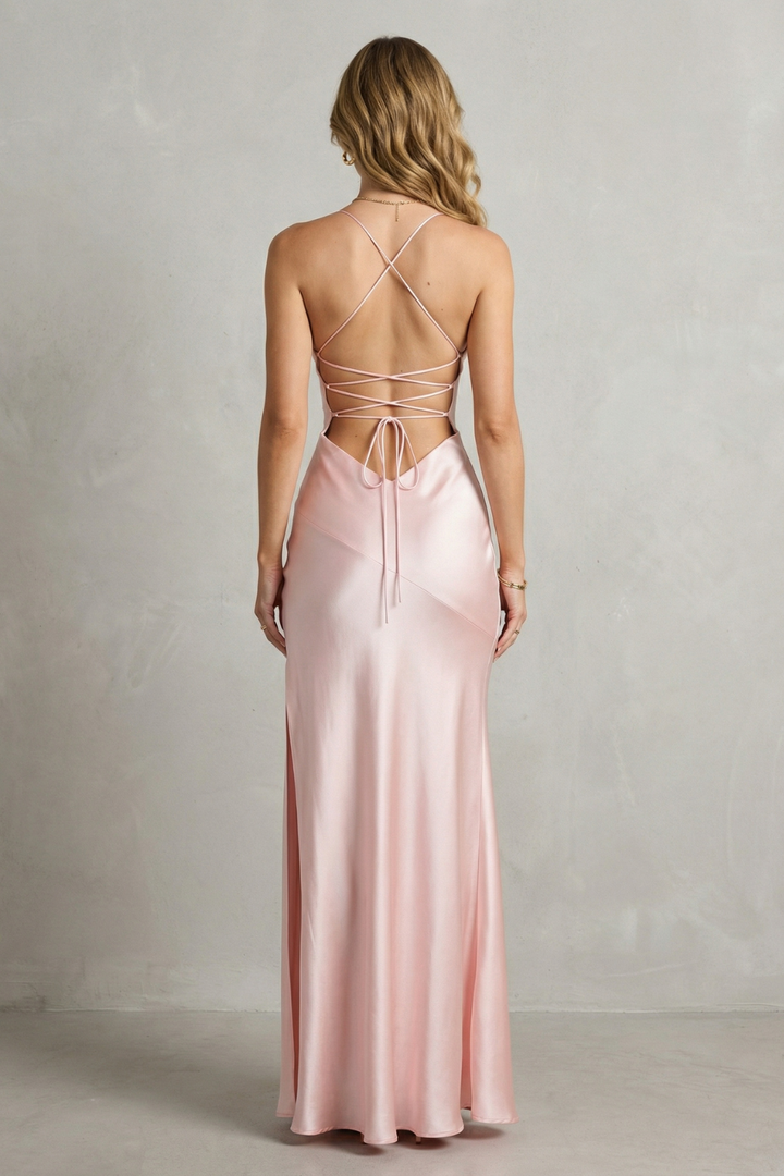 Pink satin maxi dress back view with crisscross straps and high slit.