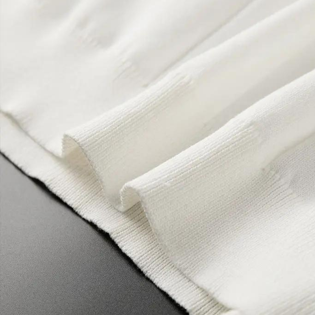 Close-up of white polo knit cuffs with ribbed trim and fine texture