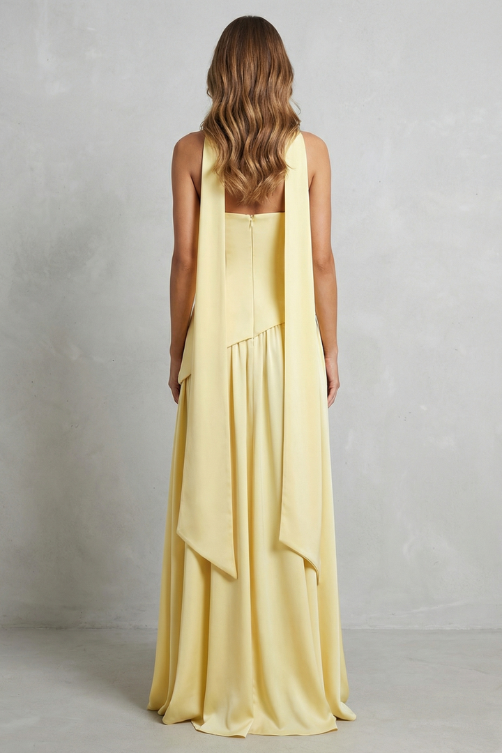 Back view strapless maxi dress in pale yellow with draped overlay hem