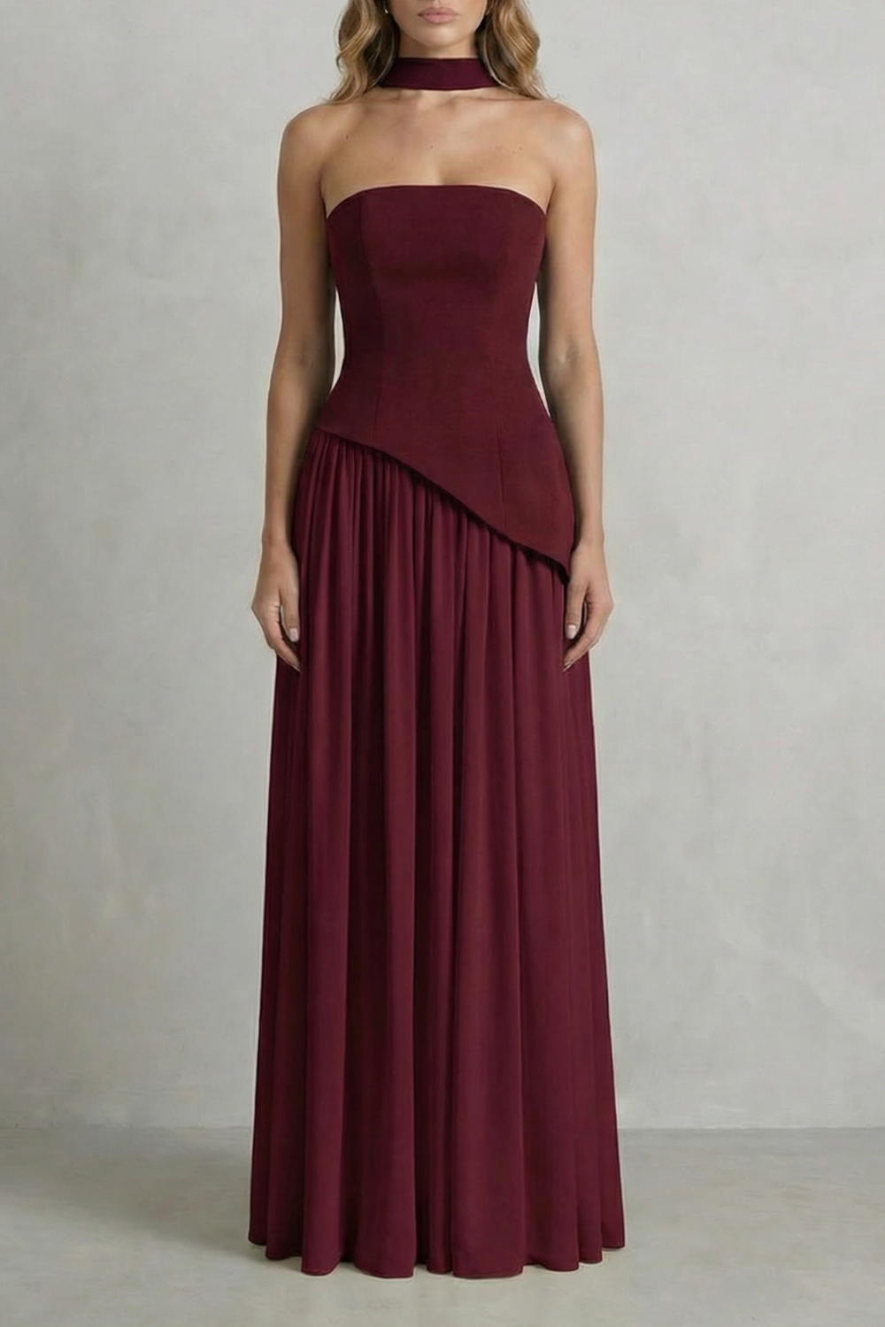 Burgundy strapless draped maxi dress with diagonal wrap overlay and pleated skirt
