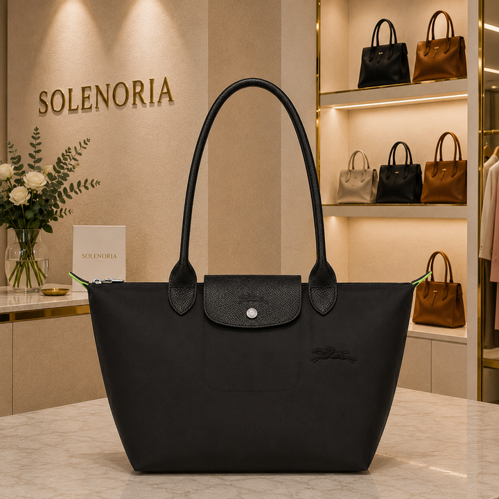 Medium black tote bag with long handles and front flap snap pocket