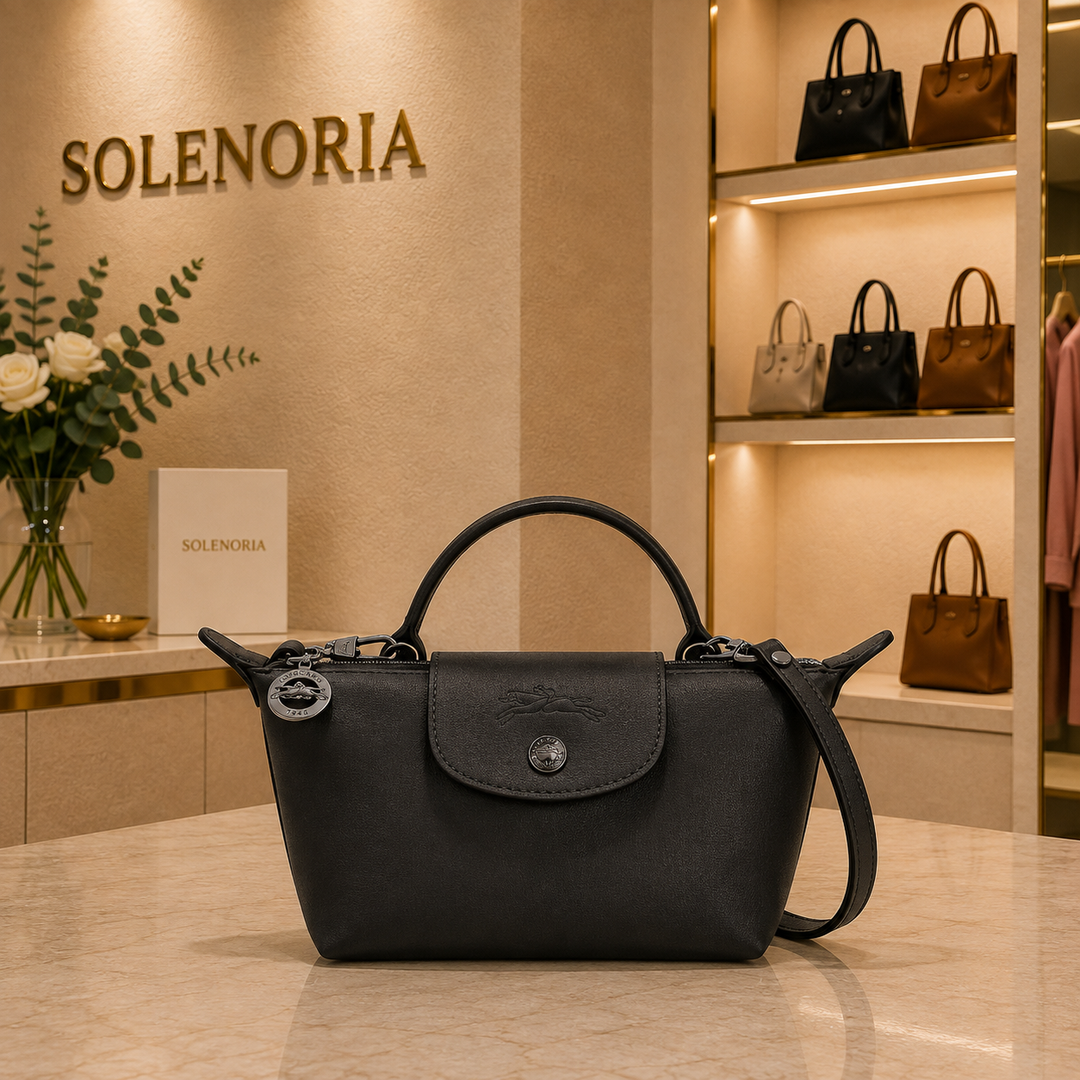 Black mini leather tote bag with front flap and snap button, two top handles