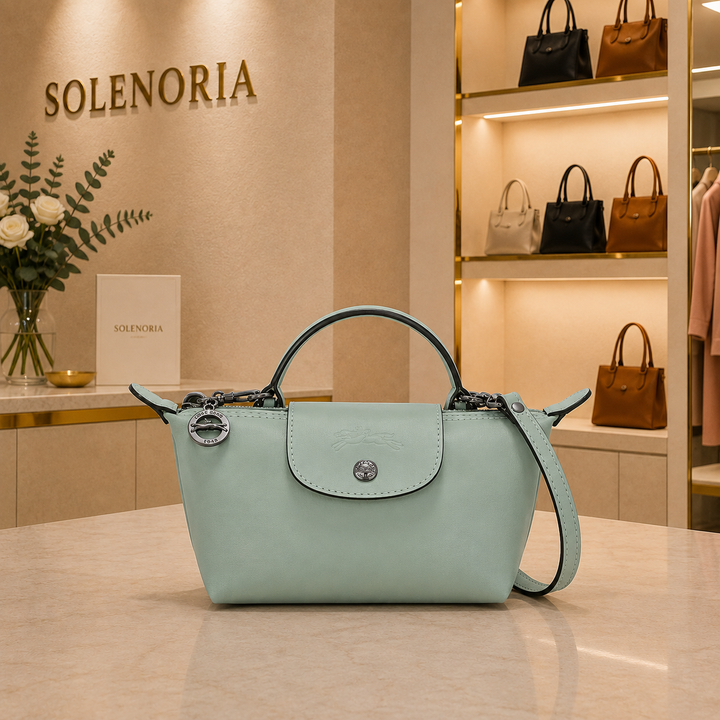 Light blue mini leather tote bag with front flap and top handle, crossbody strap