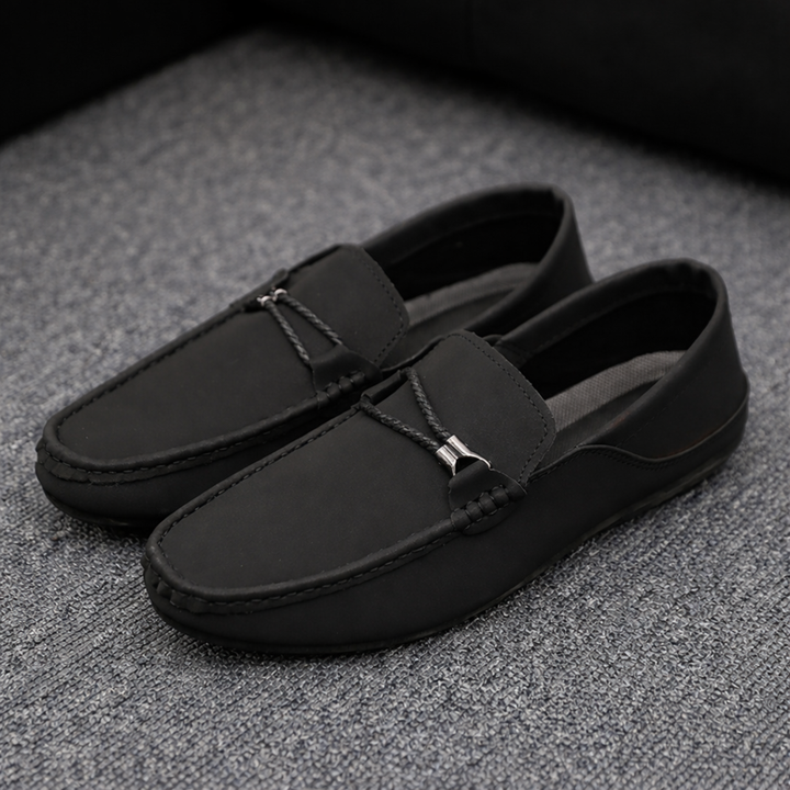 Black casual loafers with braided strap detail and metal buckle