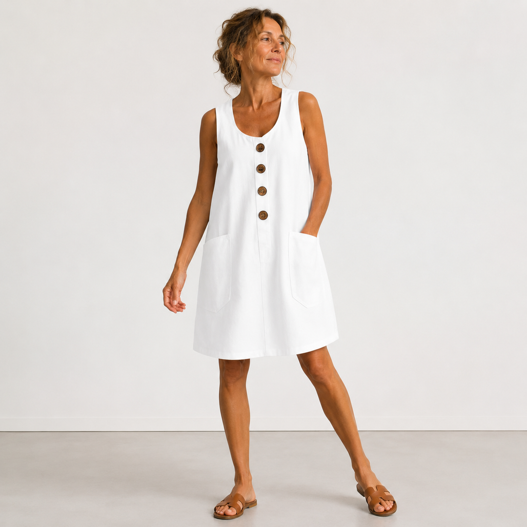 White sleeveless linen dress with button front and side pockets, A-line hem.