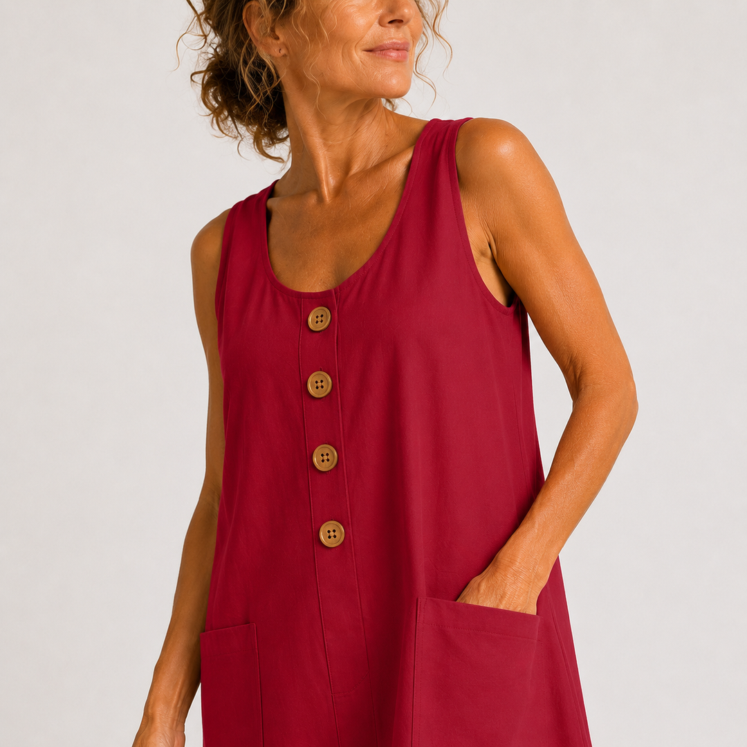 Red sleeveless linen dress close-up with wooden button placket and two patch pockets.