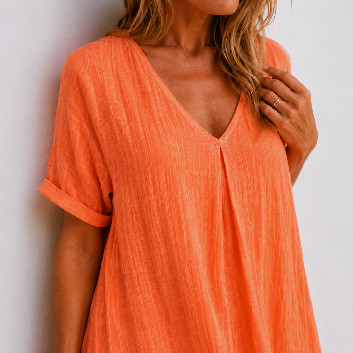 Orange linen V-neck dress close-up with short sleeves and buttoned front detail