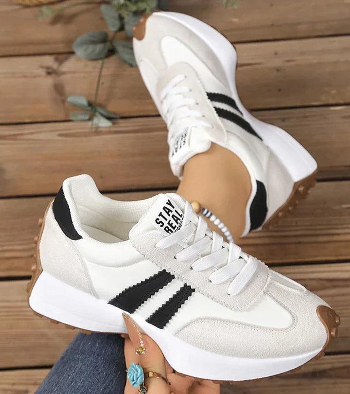 White and gray lace-up sneakers with chunky sole and black striped side detail