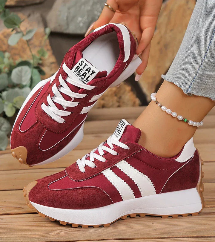 Red and white lace-up sneakers with striped side panels and white rubber sole