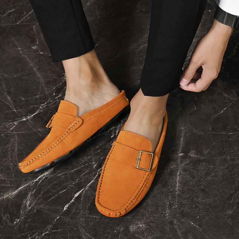 Tan-orange suede loafers with buckle detail and decorative stitching, side view