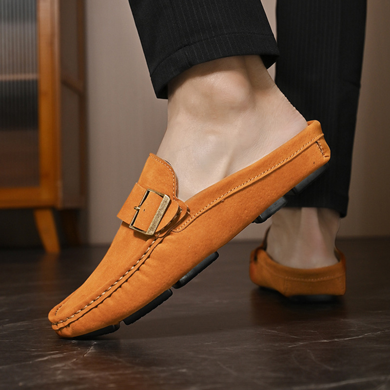 Orange suede loafers worn with dark pants, slip-on buckle strap detail