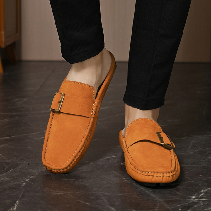 Brown suede loafers with metal buckle strap and stitched moccasin edge