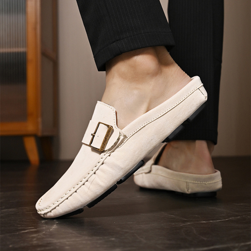 Cream suede loafers with metal buckle strap, worn with rolled trousers