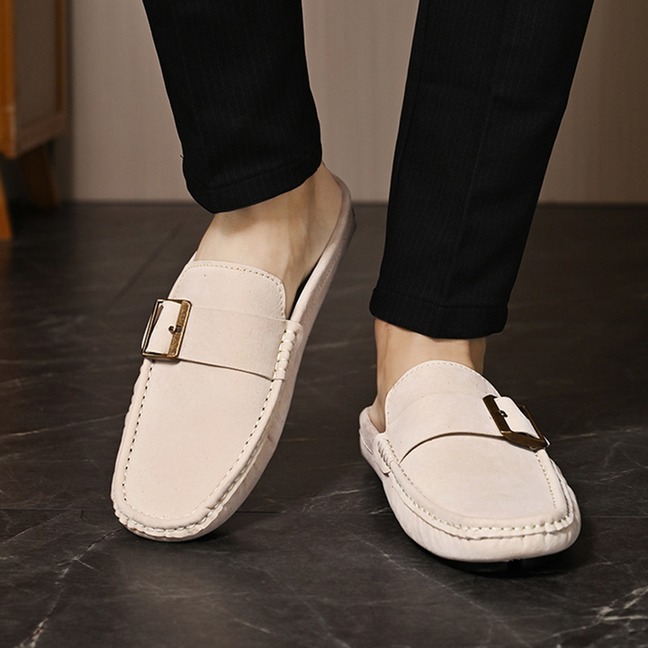 Cream suede loafers with metal buckle strap, front view on feet