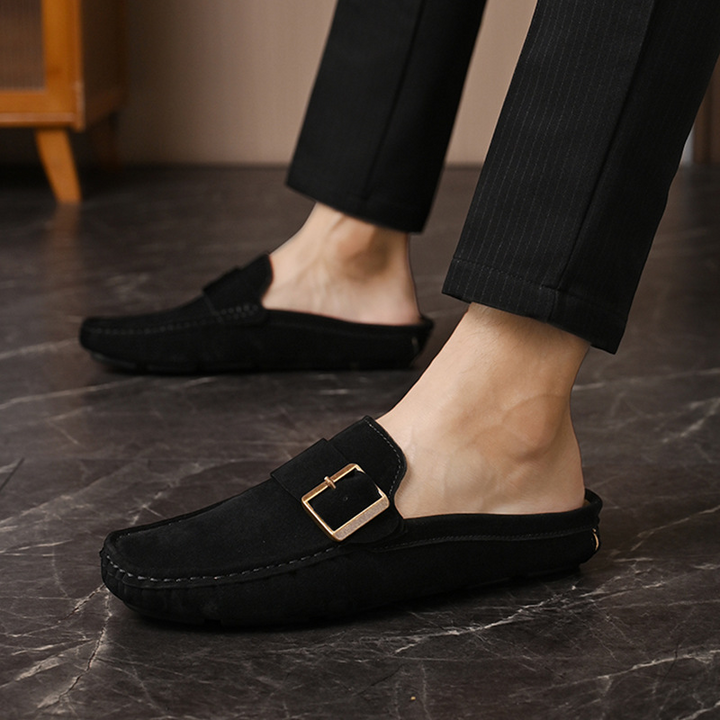 Black suede slip-on loafers with square metal buckle and stitched edges