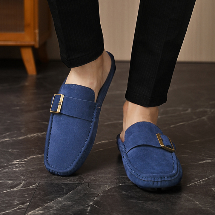 Navy suede loafers with gold buckle strap, side view