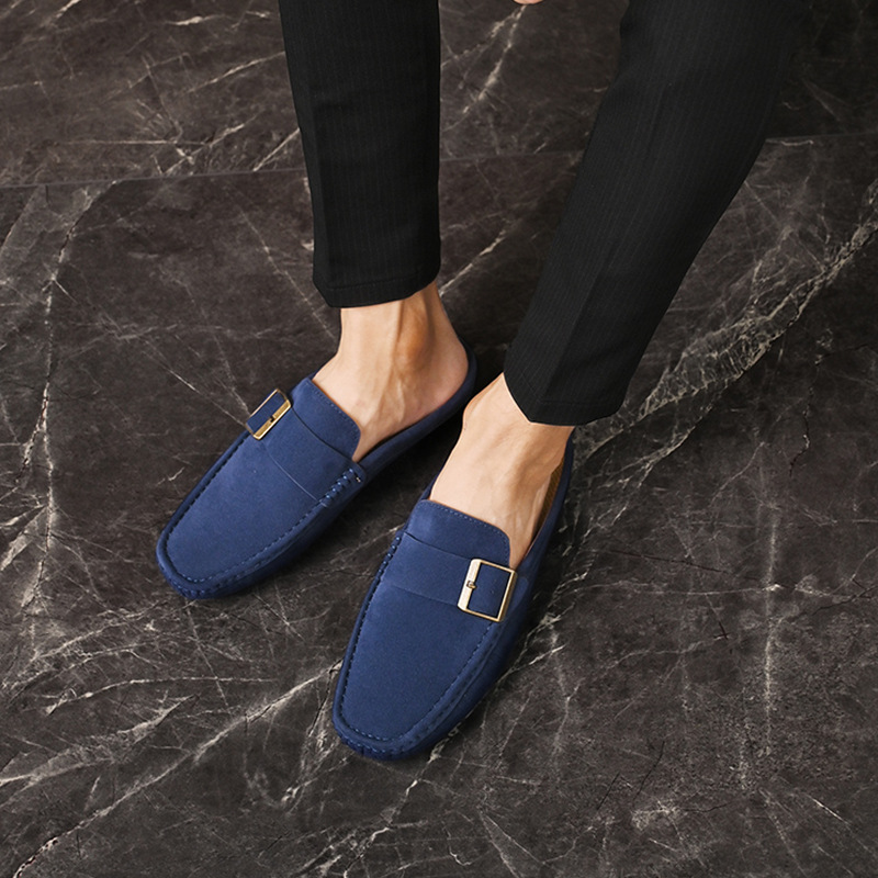 Navy suede loafers with gold buckle strap, worn with dark pants