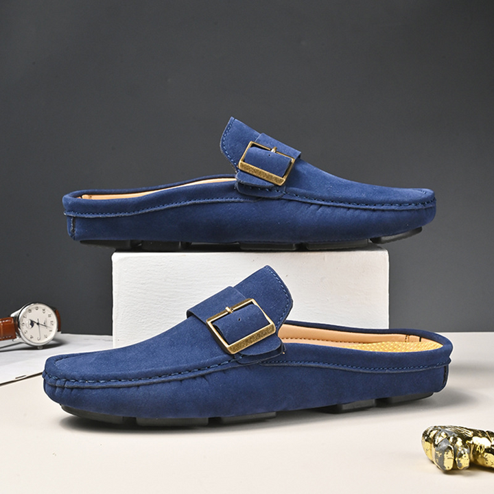 Navy suede loafers with gold buckle strap, closed-toe moc stitching