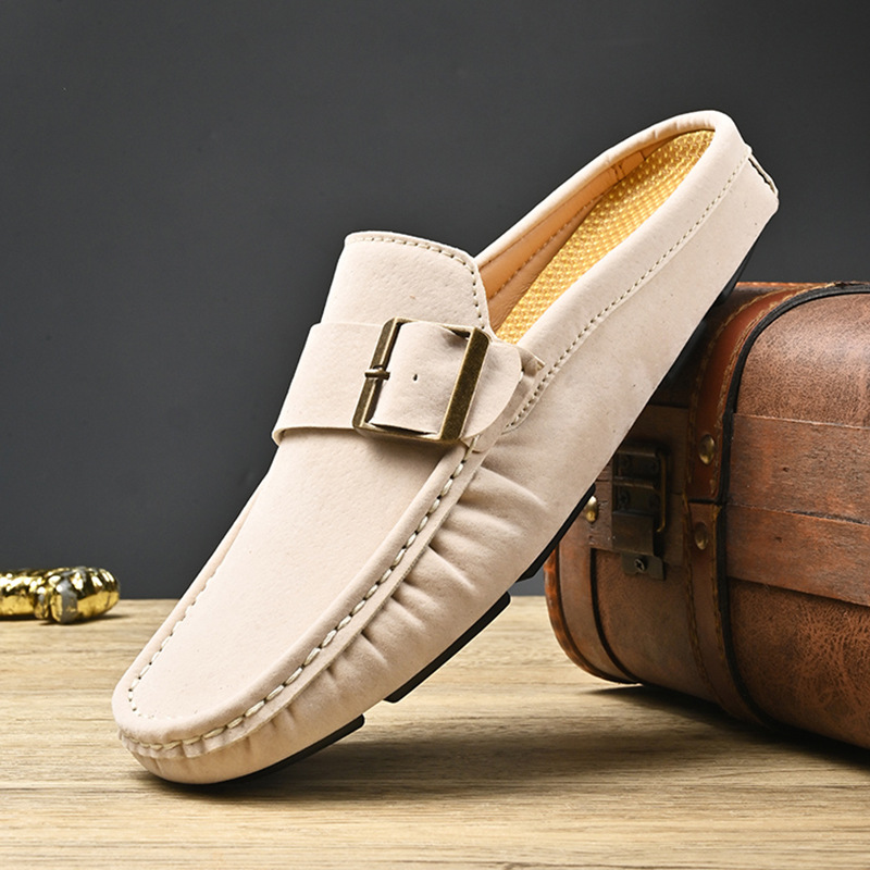 Cream suede loafers with metal buckle strap and stitched trim, angled view